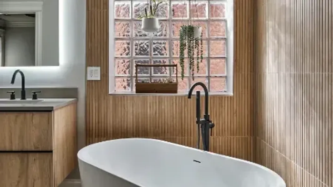 Natural spa-like bathroom with white freestanding tub and floating vanity