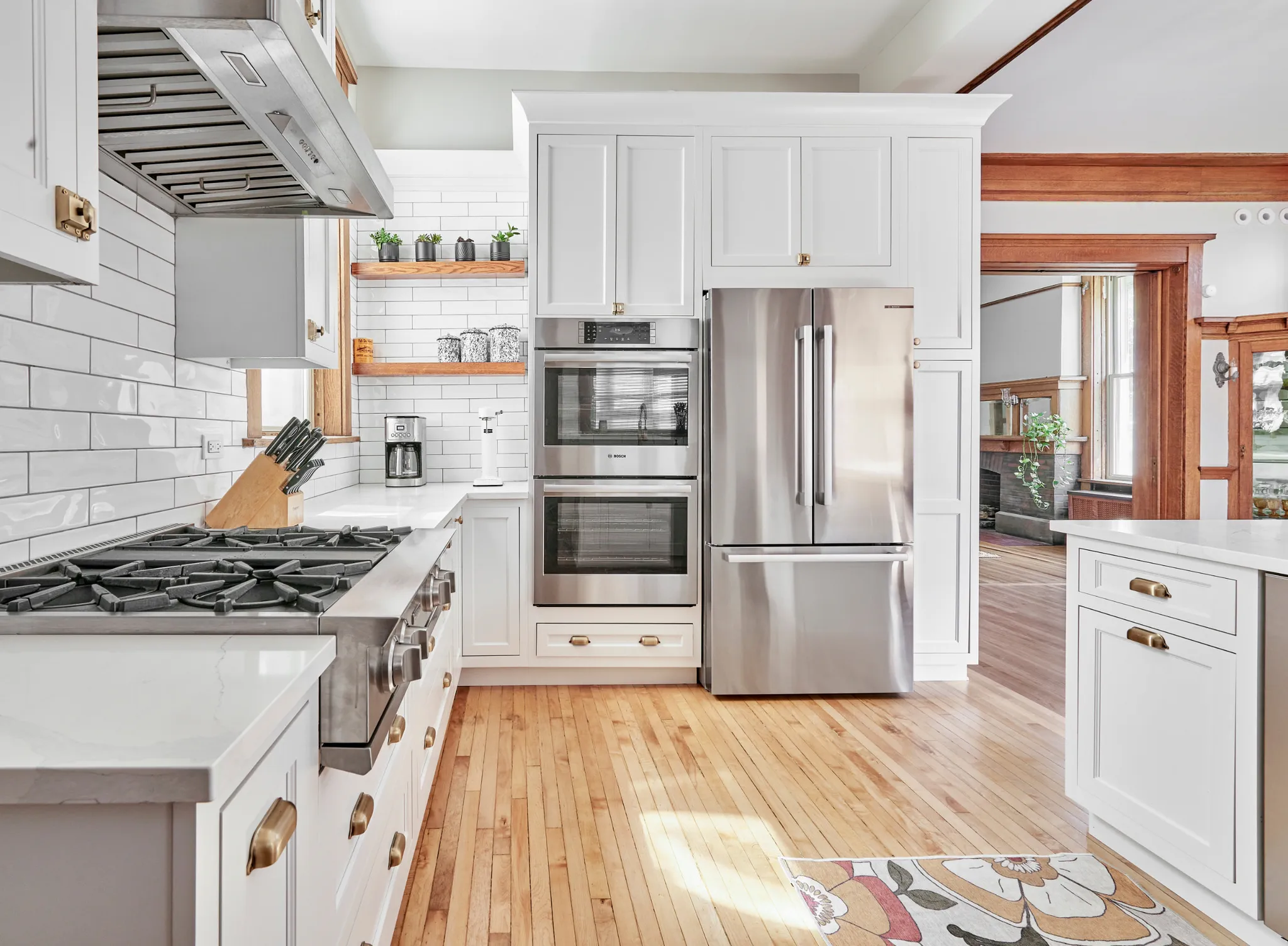 Open layout kitchen and dining room with large island, white backsplash and gray cabinets